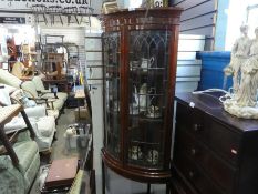 A mahogany bow fronted corner glazed cabinet with 2 doors and open shelf below