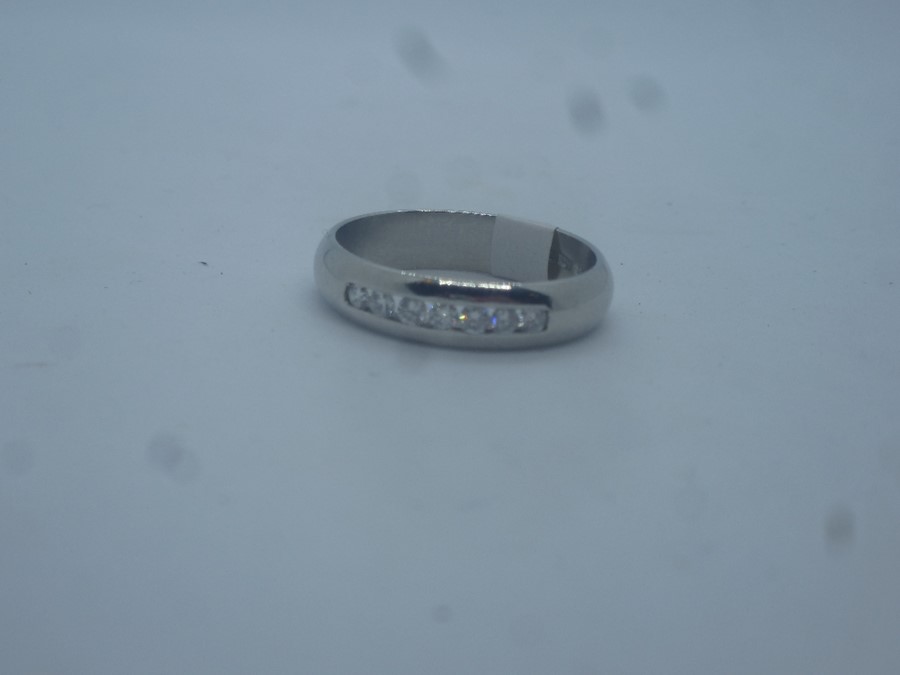 Platinum band ring with channel set brilliant cut diamonds, approx 6.5g, marked 950