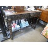 An old carved oak hall table having pierced back with two drawers on barley twist legs, 121cms