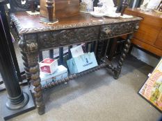 An old carved oak hall table having pierced back with two drawers on barley twist legs, 121cms