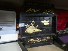 A small black case containing medicine bottles and a vintage wooden oriental storage case with 9 sma