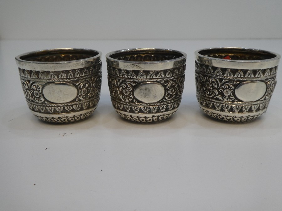 A set of three Victorian silver small embossed cups very decorative and ornate. Hallmarked London 18