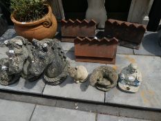 A selection of garden ornaments to include horse heads, pig, cat, etc and three terracotta ridge til