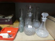 A selection of glass decanters and vintage bottles, etc and books