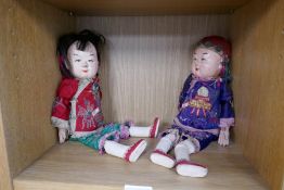 Two antique oriental dolls having papier mache heads with embroidered costumes
