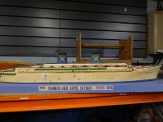 A model speed boat with remote control and a plastic model of Chandris Lines, R -HMS Britain on a wo