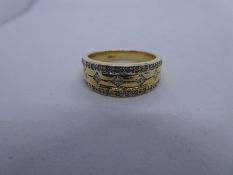 18ct yellow gold ring with 5 0.05 Carat diamonds and 14 graduated diamond chips to each rim of the r