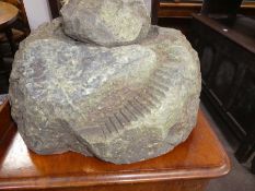 An old serpentine lighthouse lamp on associated rock base with flight of steps - some damage