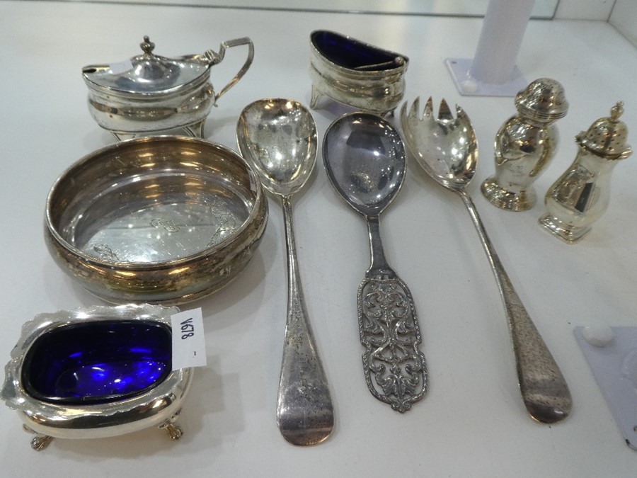 A silver lot to include Salts with Bristol blue glass insert, salt and pepper, serving spoons and co