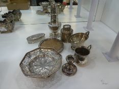 A silver lot comprising of a silver sugar sifter, silver topped cut glass trinket pot, silver small