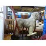 A vintage push along toy dog