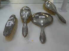 Silver backed dressing table items consisting of three brushes and a hand mirror, hallmarks to inclu