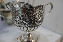 Silver ornate trinket box on four dainty feet, marks worn with a decorative trophy cup of foliate de