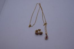 Pretty 9ct yellow gold neckchain hung with a cluster pendant with central ruby surrounded diamond ch