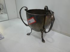 A silver three handled cup on three feet, hallmarked Sheffield 1960, Walker & Hall 3.34ozt approx