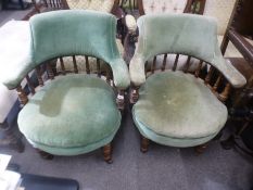 A pair of antique oak tub chairs having spindle backs