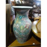 A large ceramic urn with flower and leaves and a large sitting china cheater