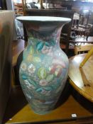 A large ceramic urn with flower and leaves and a large sitting china cheater