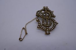 Unmarked yellow metal brooch of interlocking initials ISB, inset with seed pearls with yellow metal