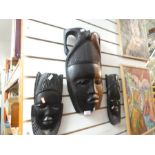 Three carved African masks one of large proportion and heavy