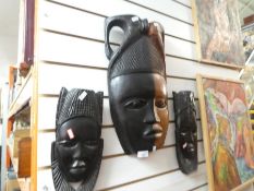 Three carved African masks one of large proportion and heavy