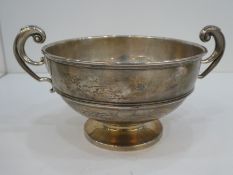 A silver two handled bowl on a pedestal foot and decorative handles, hallmarked London 1911, Robert