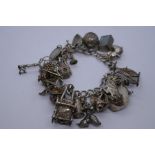 Vintage silver charm bracelet hung with approx 20 charms incl. hedgehog, key, ice skate etc 102.5g