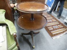 An antique mahogany two tier dumb waiter on a tripod base