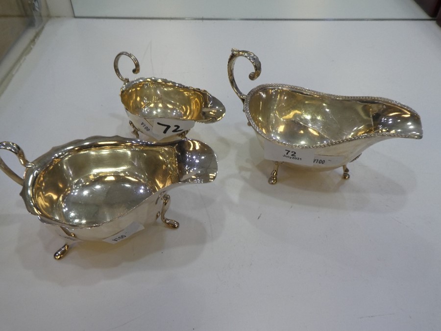 Three silver sauceboats of various sizes on three feet, decorative designs and different hallmarks,