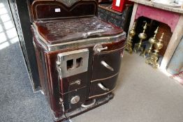 An old brown enamelled cast iron croissant stove, probably 1950s bearing initials PV, 51cm