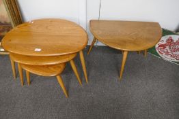 An Ercol medium oak nest of pebble tables and a similar coffee table, having a single flap