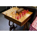 A 19th Century carved ivory chess set with a Victorian mahogany chess table and a box of draughts