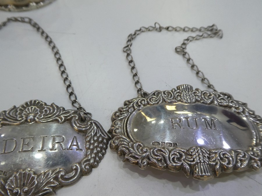 Four silver decanter labels of ornate decoration and various hallmarks and a pair of thick, silver n - Image 10 of 10