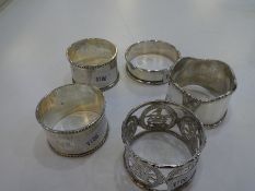 A quantity of five silver napkin rings, one being from Asia, including floriated rim, beaded rims, p