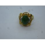 14L yellow gold ornate design ring set with oval green hardstone, possibly Jade and 4 small diamonds