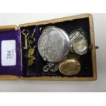 A wooden box containing a circular silver matchbox pendant, other gold plated locket silver button h