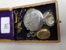 A wooden box containing a circular silver matchbox pendant, other gold plated locket silver button h