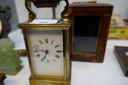 An old brass carriage clock with tatty leather case