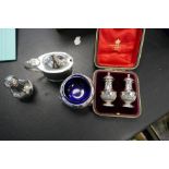 Two silver salts with Bristol blue inserts, a silver pepper and a cased set of two very nice peppers