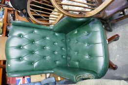 A green leather revolving desk chair, with buttoned sea and back