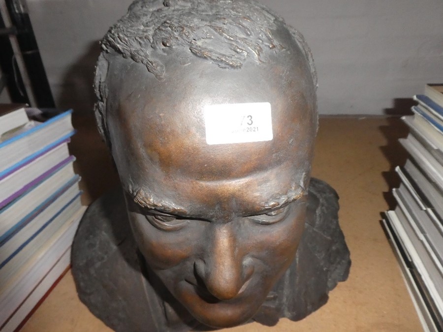 A bronze bust of men with bow tie signed to reverse 'Quinton'