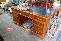 A reproduction Yew wood twin pedestal desk having nine drawers