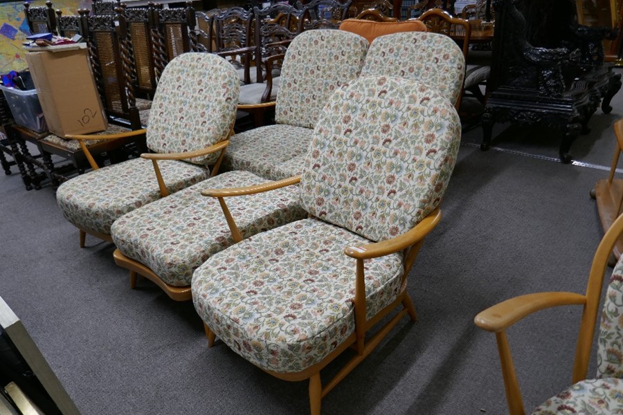 An Ercol light oak settee with pair of matching armchairs and a footstool