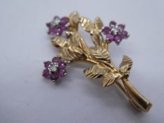 Unmarked yellow metal brooch depicting a floral spray set with rubies and diamonds, 3.5cm, approx 2.