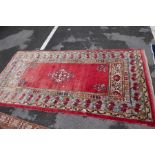 An Afghan rug having central medallion with floral border and a Persian rug with central spandrel, t