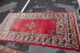 An Afghan rug having central medallion with floral border and a Persian rug with central spandrel, t