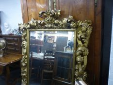 A late 19th Century carved wood and gilt mirror, the frame decorated with Acanthus leaves and flower