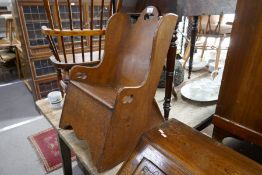 An antique oak child's rocking seat
