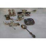 A silver lot comprising of silver salts, peppers, spoons, tongs and a small white metal tray.  Salts