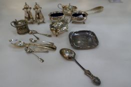 A silver lot comprising of silver salts, peppers, spoons, tongs and a small white metal tray.  Salts